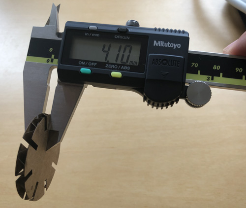 Measuring cardboard piece with calipers